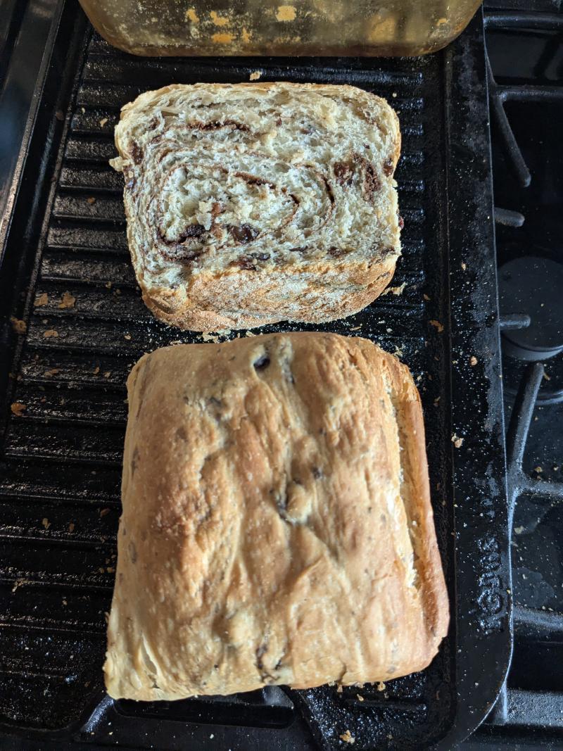 A loaf of cinnamon raisin bread on a wooden cutting board